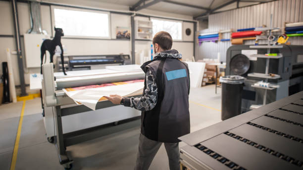 istock Technician works in large printing press hall and printshop office 1215538624