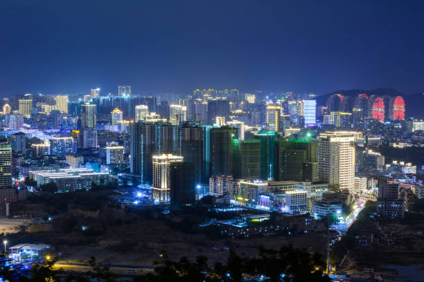 istock Night view of Sanya city with bright multi-colored illumination buildings, structures, roads, sidewalks, poles, bridges. 1215540859