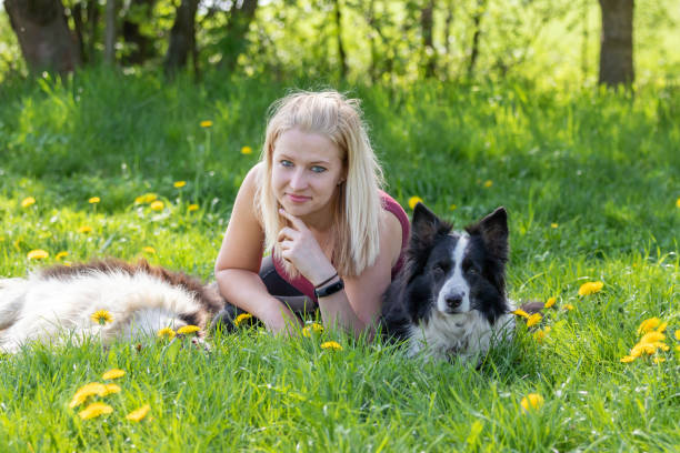 istock Smiling young blond woman is lying between two dogs 1215542407