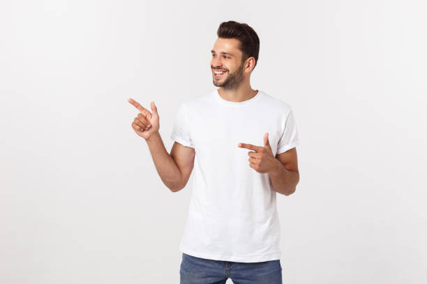 istock Man pointing showing copy space isolated on white background. Casual handsome Caucasian young man. 1215542585