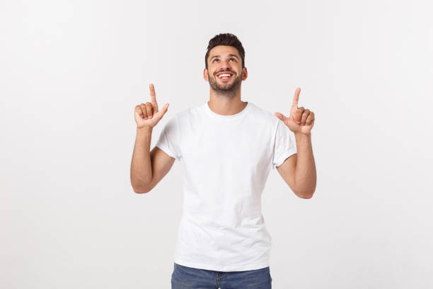 istock Man pointing showing copy space isolated on white background. Casual handsome Caucasian young man. 1215542739