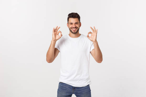 istock Satisfied young man showing okay sign isolated on white background. 1215543924