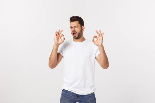 istock Satisfied young man showing okay sign isolated on white background. 1215543941
