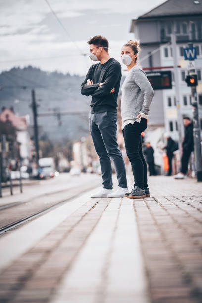 Young couple wait for train to arrive in ghost town