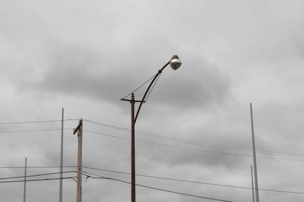 istock Composition of light, power, and antenna poles against a cloudy gray sky 1215545112