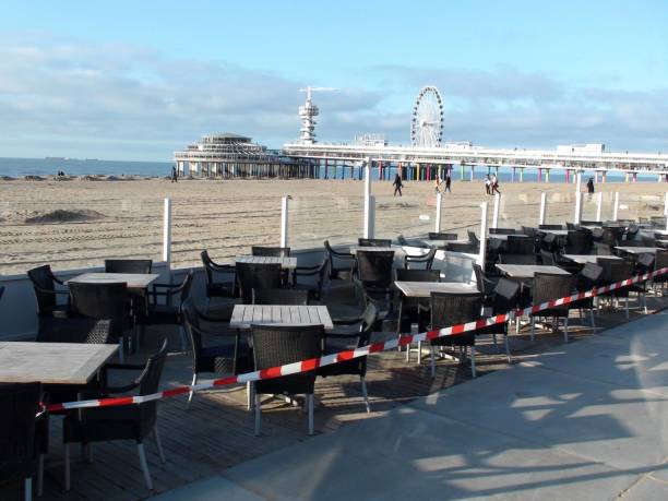 empty scheveningen beach restaurant seat do to covid 19, niederlande europa - people winter urban scene chair stock-fotos und bilder