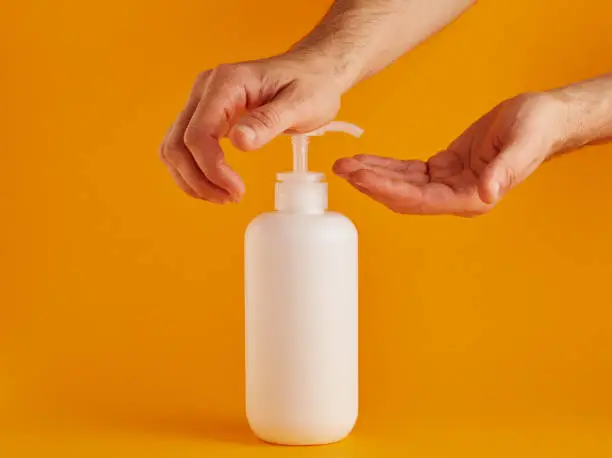 Caucasian man is using hand sanitizer disinfectant to clean his hands from viruses and bacteria