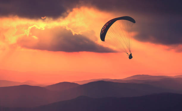 istock Paraglide silhouette flying over the mountains 1215552435