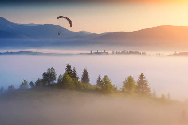 istock Paraglide silhouette in a light of sunrise 1215552621