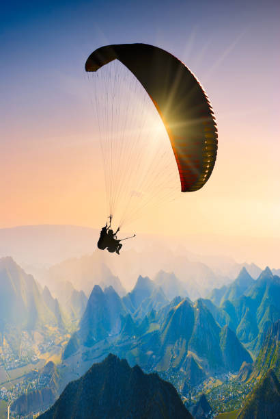 istock Paraglide silhouette over mountain peaks 1215552831