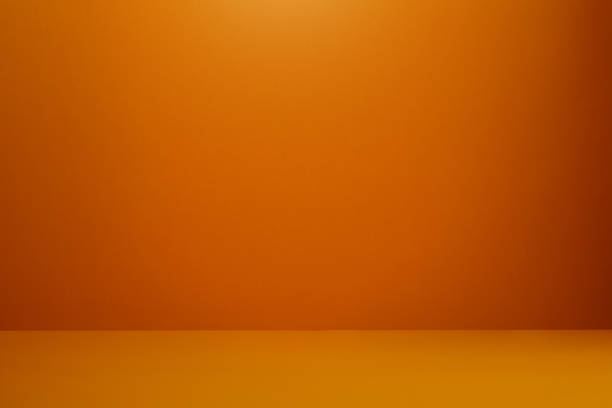 istock Orange colored wall and floor with a soft shadow at the corner 1215552885