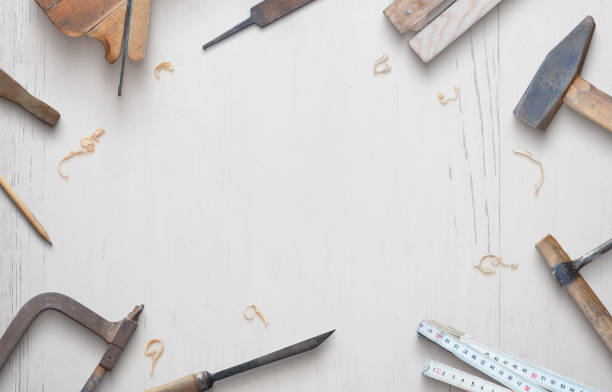 istock Woodworking tools on a white wooden table composition. Copy space in the middle. Top view, flat lay 1215556291