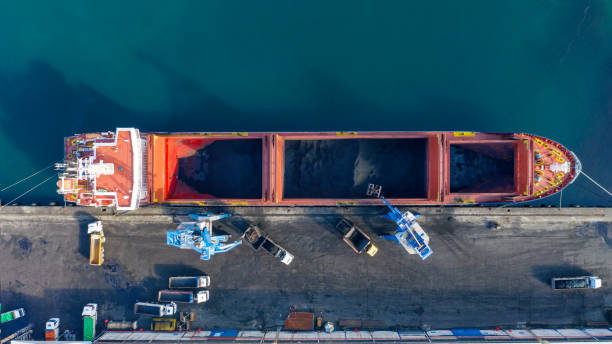 entladen von kohle auf frachtschiff in einem handelshafen. - coal crane transportation cargo container stock-fotos und bilder