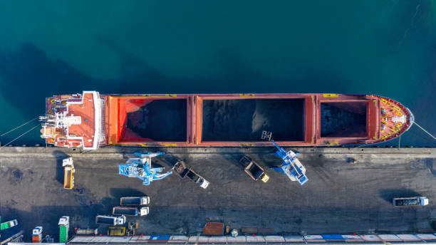 rozładunek węgla przez statek towarowy w porcie handlowym. - coal crane transportation cargo container zdjęcia i obrazy z banku zdjęć