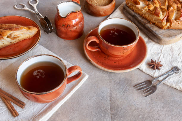 istock Apple pie, cup of fragrant tea, cinnamon sticks, anise and cutting knife in rustic style on a wooden background 1215561185
