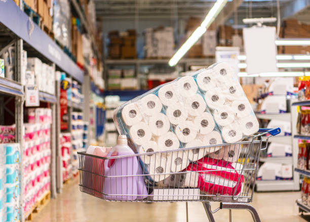 Shopping cart full with products in a large supermarket Shopping cart full with products in a large supermarket toilet paper photos stock pictures, royalty-free photos & images