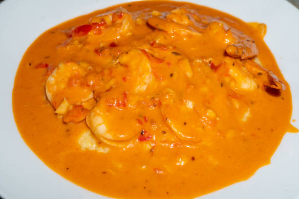 creamy shrimp and grits in a tomato based sauce - grits prepared shrimp restaurant food imagens e fotografias de stock