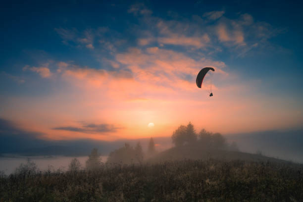 istock Paraglide silhouette flying at early morning 1215561474