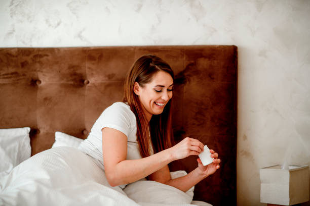 istock Young woman taking pills in bedroom 1215564737
