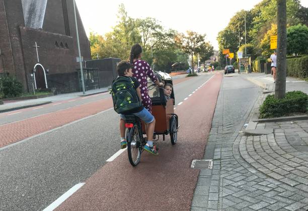 kvinnor med barn på lastcykel - parents children cargo bike bildbanksfoton och bilder