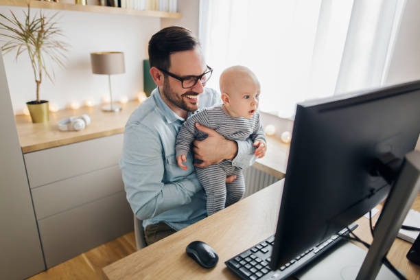 istock Young father working from home and holding his baby boy. 1215566767