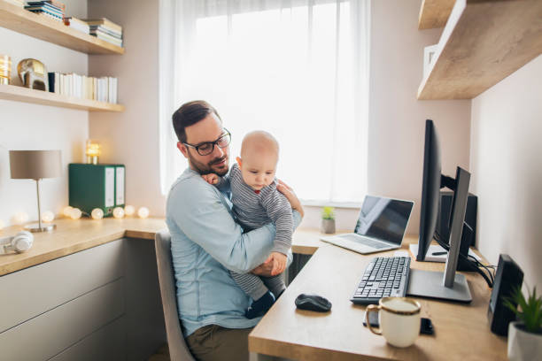 istock Young father working from home and holding his baby boy. 1215566781