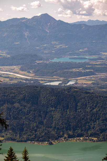 panorama de los alpes austriacos en el lago ossiacher ver con las montañas de las montañas karawanken con parapentes - paragliding sport austria parachuting fotografías e imágenes de stock