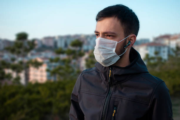 Isolated young man wearing mask looking towards in concern stock photo