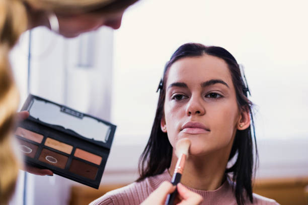 istock Makeup artist applying blush to her makeup model 1215568073