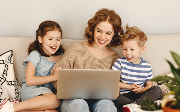 istock Happy mother with kids using laptop at home 1215568611