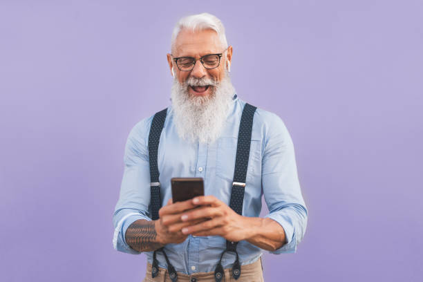 hombre mayor usando teléfonos inteligentes móviles y escuchar música con airpods - happy maduro hombre divirtiéndose con nuevas tendencias tecnología aplicaciones de medios sociales - personas de estilo de vida de edad avanzada y concepto de adicción - mobile phone telephone bluetooth men fotografías e imágenes de stock