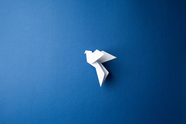 istock Paper pigeon on a blue isolated background. 1215574110