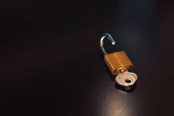 istock Padlock with key isolated on black background 1215574450