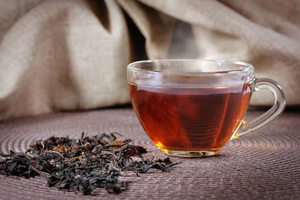istock A cup of black tea and leaves on a dark background. 1215574580