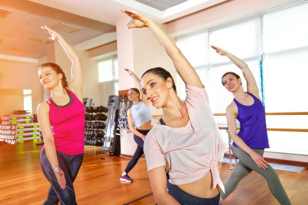 istock Group of young sporty attractive people practicing yoga lesson with instructor, standing together in exercise, working out, full length, studio background, close up 1215575730