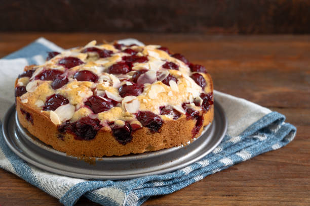 istock freshly baked small cherry cake with almond slivers, rustic wood and dark background with copy space, selected focus 1215576052