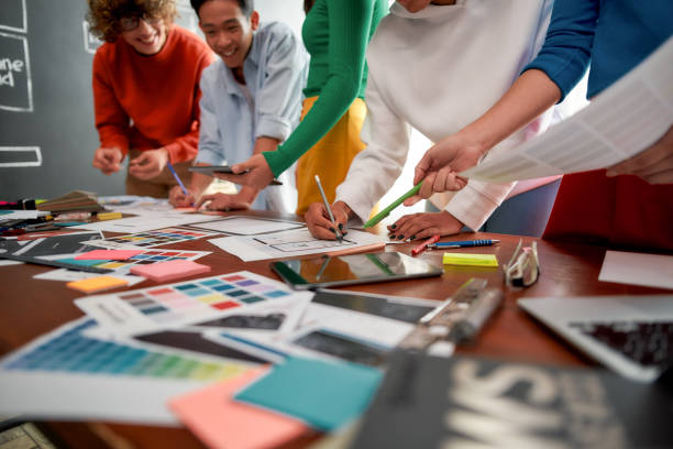 istock Graphic design team. Cropped photo of creative people prototyping new web site design for a client while having a meeting in the modern office. Creative agency concept 1215577012