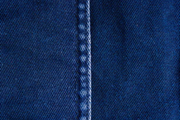 istock clothing items stonewashed cotton fabric texture with seams, clasps, buttons and rivets, macro 1215577955