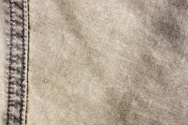 istock clothing items stonewashed cotton fabric texture with seams, clasps, buttons and rivets, macro 1215578059