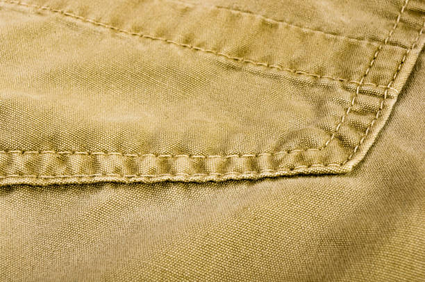 istock clothing items stonewashed cotton fabric texture with seams, clasps, buttons and rivets, macro 1215578099