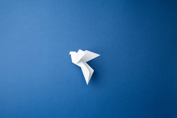 istock Paper pigeon on a blue isolated background. 1215578199