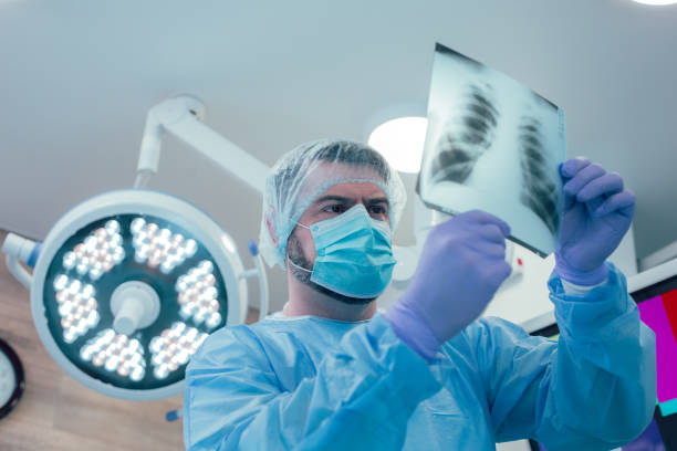 médecin attentif analysant le rayon x de sa photo de stock patient - surgical needle photos photos et images de collection