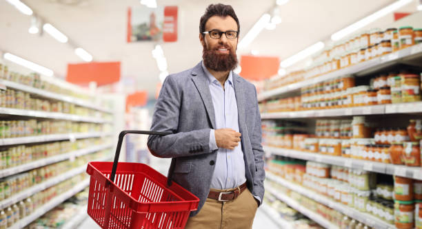 istock Bearded man holding a shopping basket inside a supermarket 1215580958