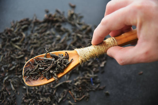 istock Man hold herbal wellness dry tea in spoon. 1215581456