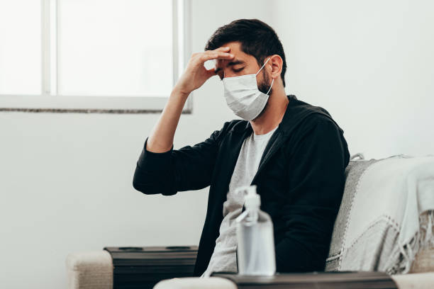 coronavirus, covid-19 e concetto di quarantena. uomo malato con sintomo di mal di testa - sintomo foto e immagini stock