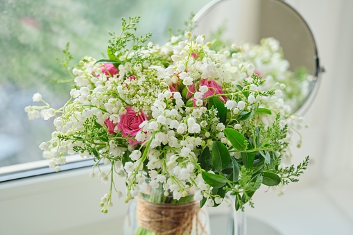 Springtime, spring fresh bouquet of lilies of the valley, pink roses, blooming viburnum.