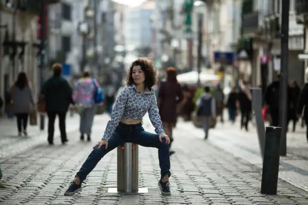 Young asian woman posing on the Santa-Catarina street in Porto, Portugal.