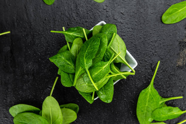 istock Fresh Spinach on a dark slate slab (close-up shot) 1215584717