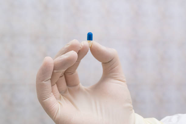istock Blue and white pill in doctors hand 1215586331