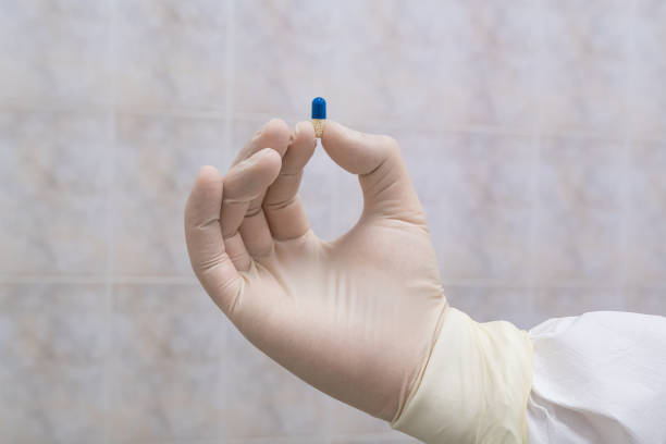 istock Blue and white pill in doctors hand 1215586366
